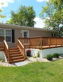 Home with large wraparound deck and landscaping at Knollwood Estates