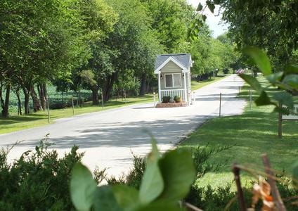 Tree-lined street with gatehouse at Knollwood Estates