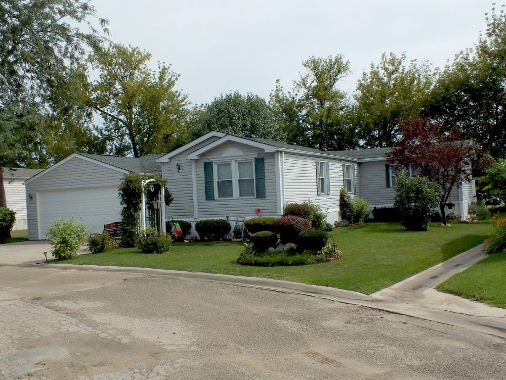 White manufactured home on corner lot at Knollwood Estates